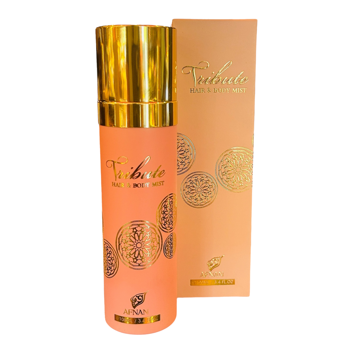 Afnan Tribute Hair & Body Mist in a peach-pink bottle with gold cap and circular gold patterns, shown beside matching box.