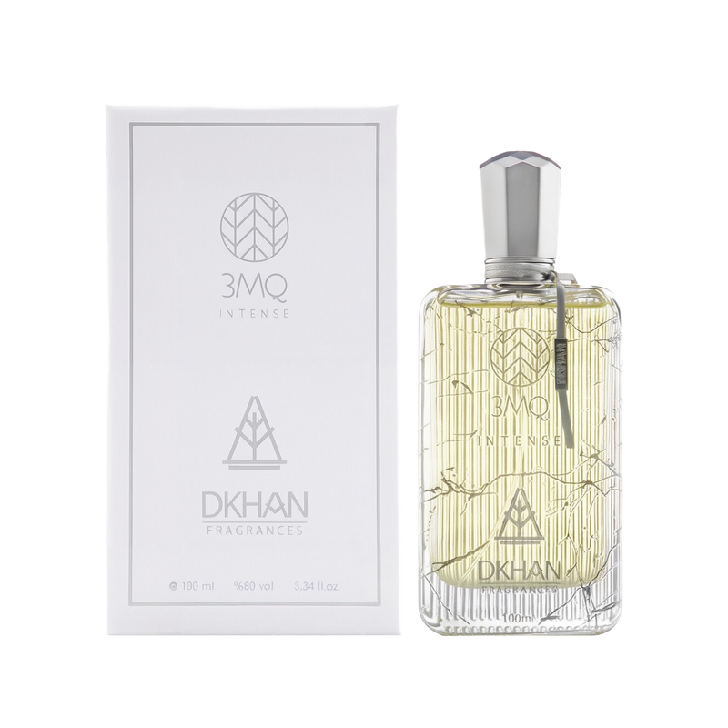 The image shows a luxurious clear glass perfume bottle with a silver cap, engraved with intricate, geometric patterns and the branding "3MQ INTENSE" in the center. To the left, the white packaging box echoes the bottle's design, with "3MQ INTENSE" and "DKHAN FRAGRANCES" emblems in a sleek, modern font. Both the bottle and box indicate the volume "100 ml", alcohol content "98% vol", and size "3.34 fl. oz." 
