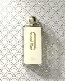 The image displays a transparent perfume bottle with a golden cap, set against a geometric patterned background composed of overlapping arches in gold and white.  Below this is the brand name "AFNAN" in smaller, capitalized letters. The product specifications "eau de parfum vaporisateur," "100ml," and "3.4fl.oz" are listed at the bottom of the label. The overall aesthetic is luxurious and modern.