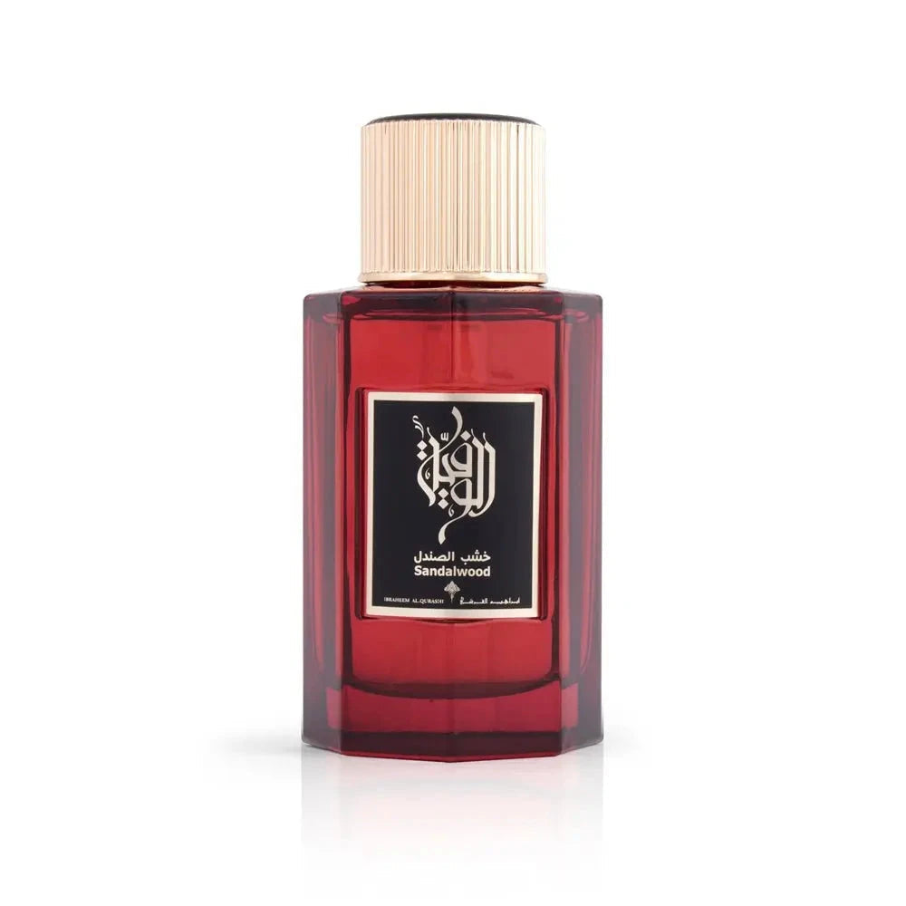 The image presents a dark red glass perfume bottle with a gold cap. The front label features elegant Arabic calligraphy above English text stating "Sandalwood," which is the fragrance name. It is from the brand Ibraheem Al Qurashi. The bottle is set against a plain white background, highlighting its design and color. The focus on the bottle without additional elements suggests a minimalist or elegant presentation, emphasizing the perfume itself.