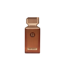 Brûlée perfume in a warm amber ribbed glass bottle with a geometric rose-gold cap, presented on a clean white background.