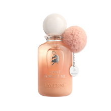 Peach gradient perfume bottle with round cap, cat emblem, and pink pom pom charm labeled “Can’t Forget Me”.