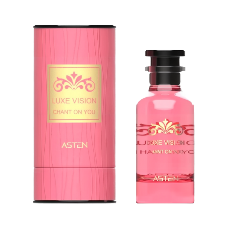 A pink, cylindrical perfume box with a gold-accented Luxe Vision Chant On You label beside a matching pink glass perfume bottle adorned with a decorative gold motif