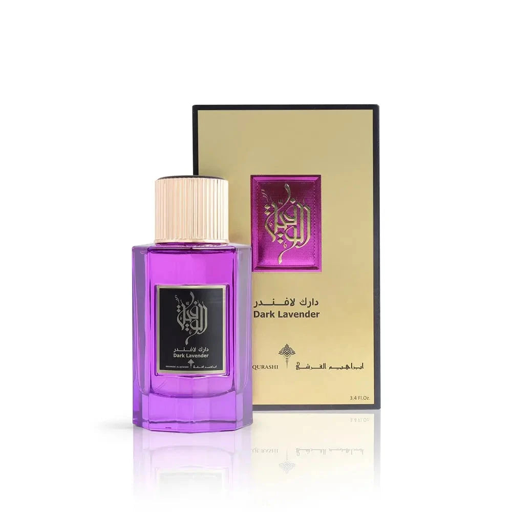 The image shows a bottle of "Dark Lavender" perfume by Ibraheem Al Qurashi in front of its packaging. The perfume bottle is made of transparent glass with a purple liquid inside, and it has a gold-colored cap. The front label has black Arabic calligraphy and English text indicating the name of the fragrance. Behind the bottle is the packaging, a box with a gold front and a black back, featuring a textured design and the same calligraphy and fragrance name in both Arabic and English. 