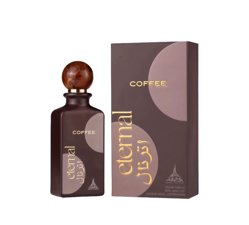 A dark brown rectangular perfume bottle with a spherical, wood-like cap labeled ‘COFFEE’ and ‘eternal’ in gold lettering alongside a matching brown box featuring the same branding and Arabic script.