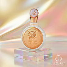 Circular white Fakhar Lattafa perfume bottle with gold detailing and an ornate emblem, set against a shimmering gold background.