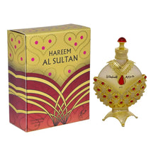 The image shows a richly decorated perfume box alongside a perfume bottle. The box has "HAREEM AL SULTAN" printed in bold, capital letters on a yellow and red patterned background, featuring heart and dot motifs, and a floral design