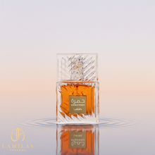 Lattafa Khamrah perfume in a faceted crystal bottle with orange liquid, reflected in water ripples.