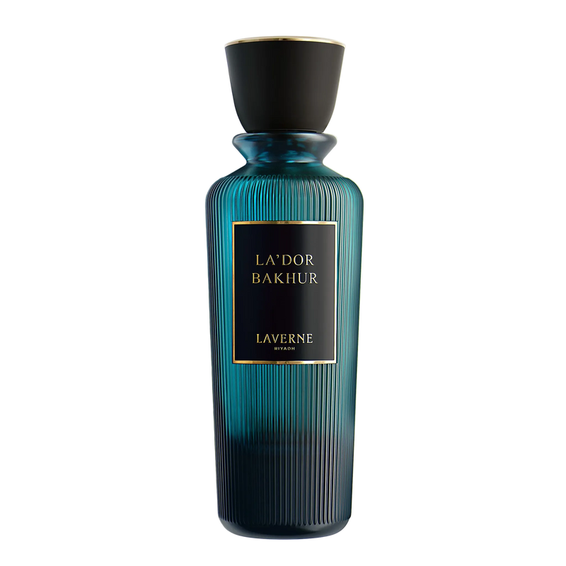 Teal ribbed glass perfume bottle with black cap and gold label reading “La’dor Bakhur” casting a shadow.