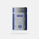 The image presents a perfume bottle with an elegant design. The bottle is clear glass with an intricate white geometric pattern covering most of its surface. It has a solid navy blue cap and a matching navy blue band that runs horizontally around the center of the bottle, providing a bold contrast to the white pattern. 