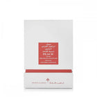 The image displays a white packaging box with a red label for a fragrance product. The label includes the name "PEACH MUSK" in English, with corresponding Arabic script above it. Below, it states "IBRAHEEM AL.QURASHI SPECIAL KHAMRIYA FOR HAIR." A red strip at the box's base matches the label, and the brand's logo is printed in red at the bottom.
