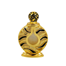The image displays an ornate perfume bottle:  The bottle has a spherical shape with a flat base, finished in a shiny gold color. It features black and gold patterned designs with inset gem-like crystals. 
