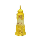 The image features a perfume bottle with a design that draws inspiration from Middle Eastern art and architecture. The bottle has a white-to-gold gradient with a predominantly frosted white upper half that transitions to a clear lower half. It is adorned with ornate gold embellishments that cover the mid-section and base, including intricate arabesques and geometric patterns typical of Islamic art. A distinctive feature of the bottle is the elaborate gold cap, which resembles the dome of a mosque.
