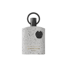 A grey, speckled fragrance bottle from Afnan’s Supremacy Collector’s Edition, featuring a circular black cap handle and an embossed black emblem on the front, displayed against a white background.