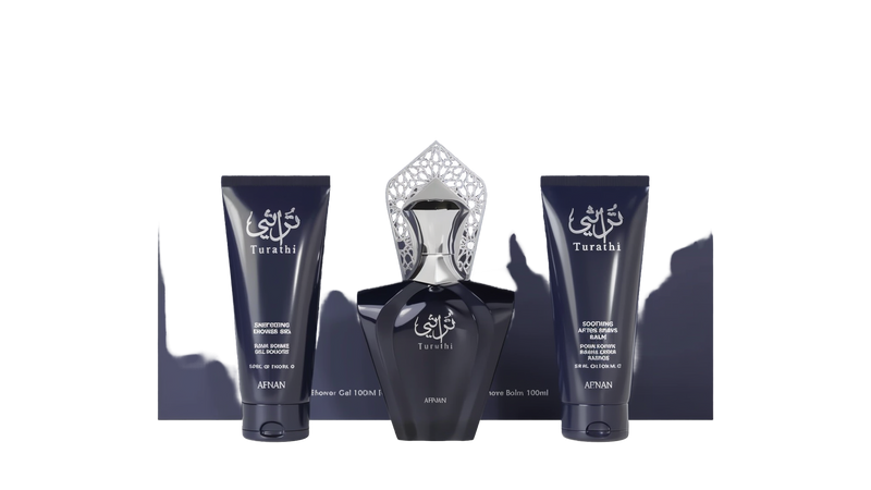 A sophisticated fragrance gift set by Afnan Perfumes, labeled "Turathi Homme Blue." The set includes three items: on the left is an energizing shower gel (100 ml) in a dark blue tube, in the center is a dark blue perfume bottle with an intricate silver ca