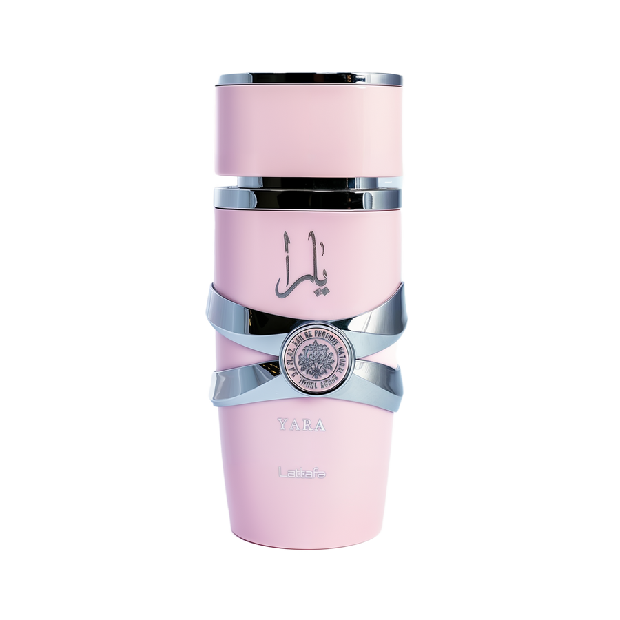 This image depicts a cylindrical, pale pink perfume bottle with the name "YARA" from the brand Lattafa. The bottle has a unique stacked design with silver bands wrapping around it, giving the appearance of three separate sections. The upper and lower sections are matte pink, while the middle section is glossy black, providing a striking contrast. A silver emblem with intricate detailing is centered on the middle band. The Arabic script, likely the name "YARA," is printed in black on the upper pink section.