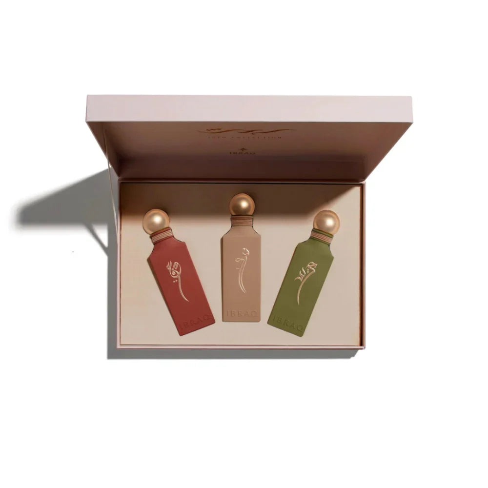 Three small bottles with gold caps in a box on a white background