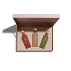 Three small bottles with gold caps in a box on a white background